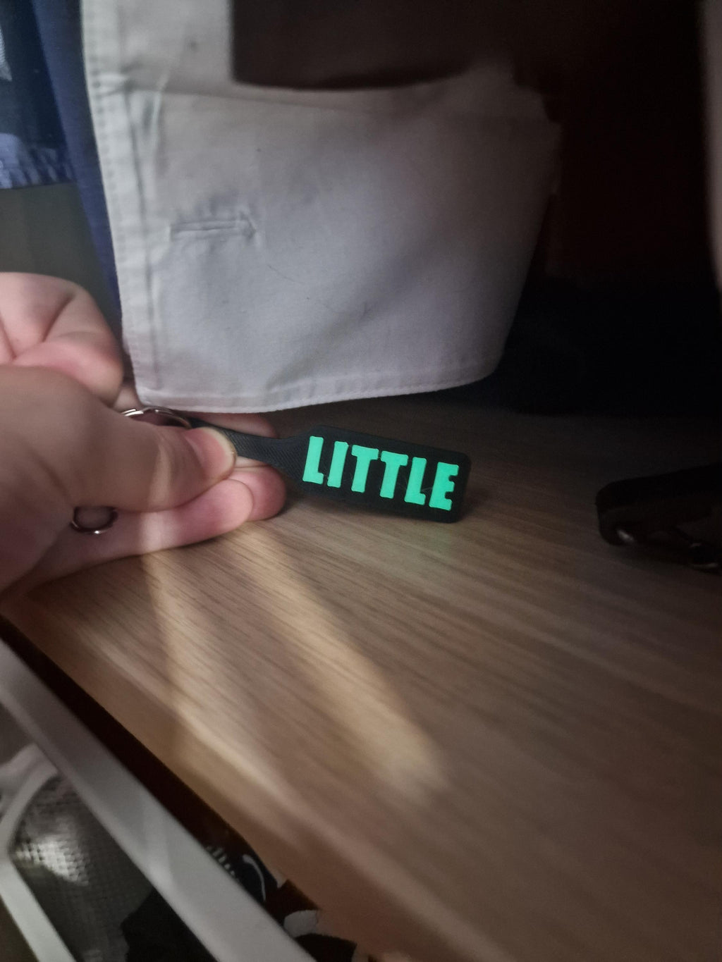 May include: Black keychain with the word "LITTLE" in bright green letters. The keychain is held in front of a wooden surface and a white shirt. (etsy image id: 7629233739)