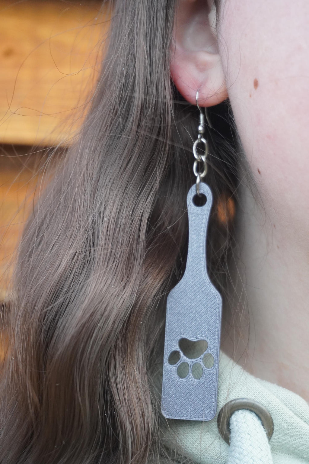 May include: Grey dangle earrings with a paw print design. The earrings are made of a textured material and have a silver hook. (etsy image id: 8005292459)